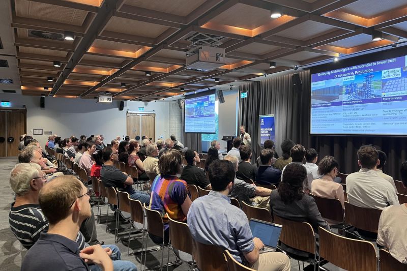 Large room of people sitting listening to a seminar speaker