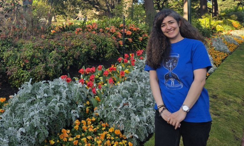 Foojan standing in garden with flowers and trees